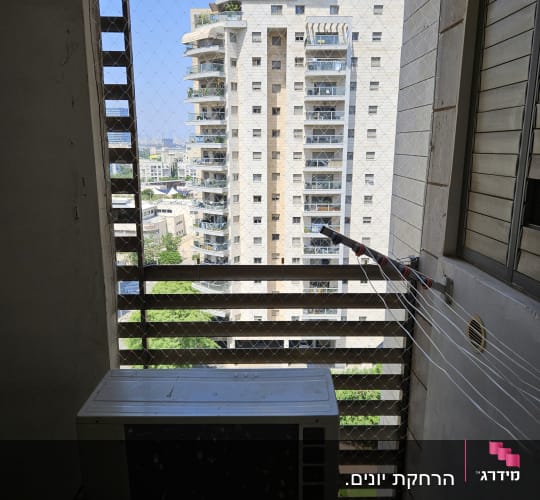 רשת נגד יונים מותקנת על חלון עם מזגן